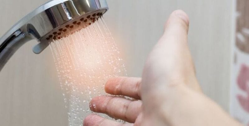 Man checks water heat before showering